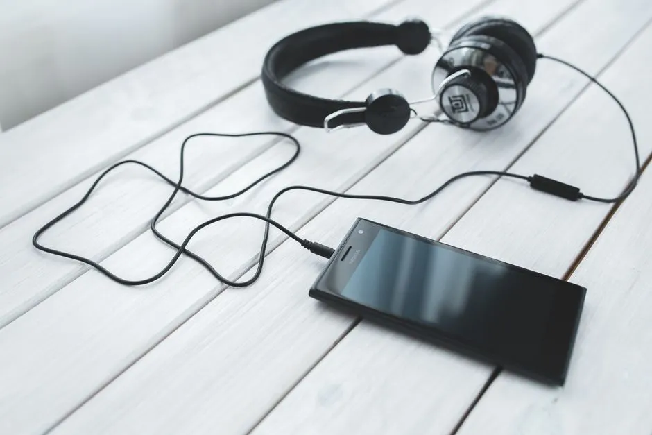 Smartphone and headphones resting on a desk